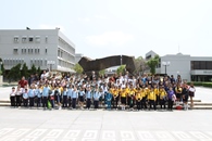 Primary school students from the Rural School Service Project gather for a group photo in front of the sculpture – the Gate outside the Main Library.